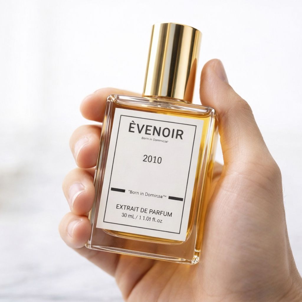 Hand holding a 30ml glass bottle of 2010 extrait de parfum with gold cap